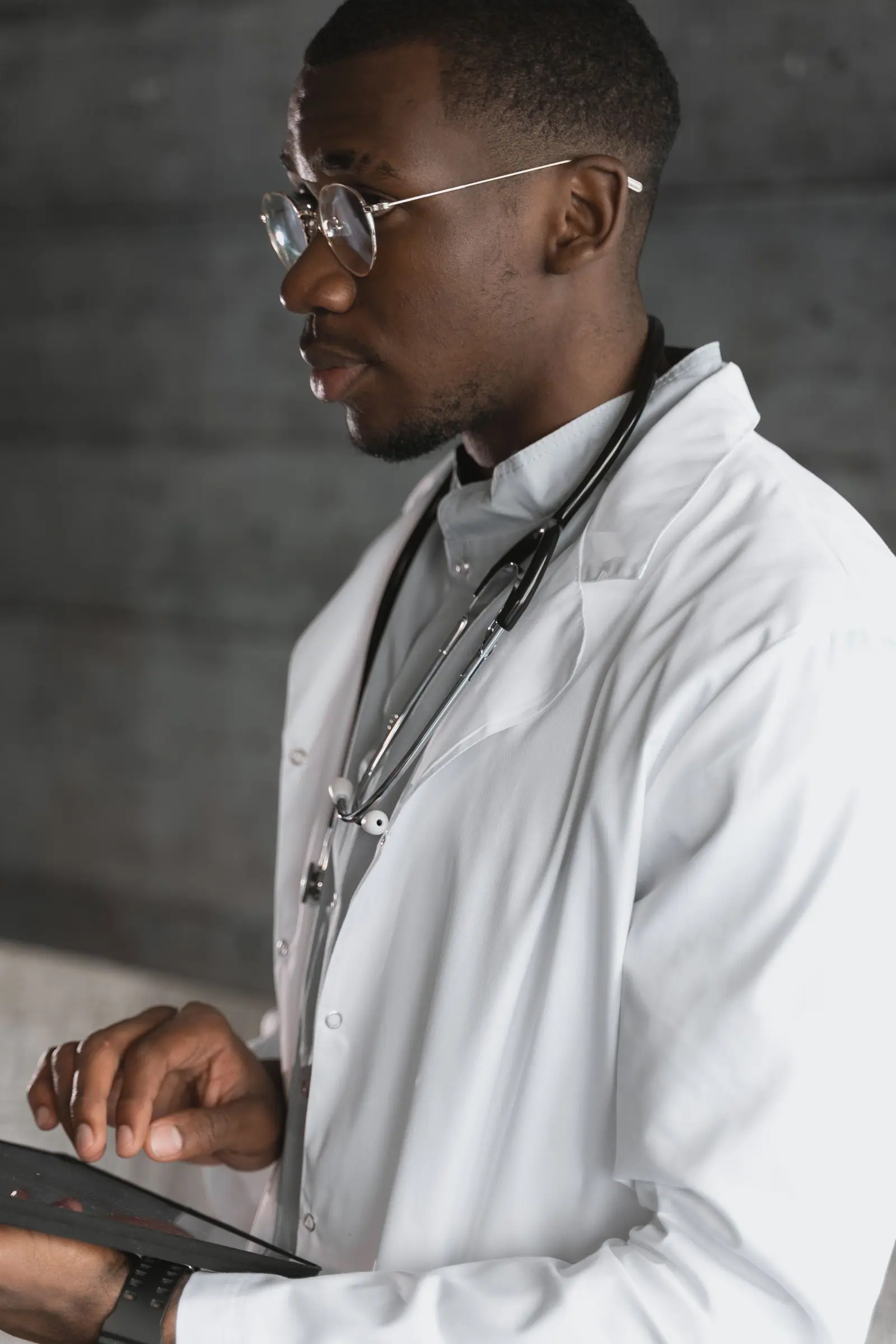 Doctor in a white coat reviewing notes on a tablet